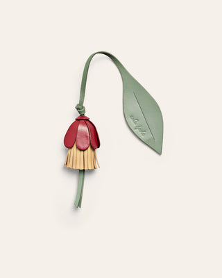 Flower shaped leather bag charm on a beige background