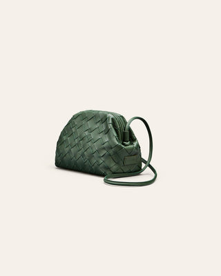 Cala Jade green woven leather clutch on a light beige background seen from the side.