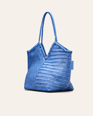 Cala Jade Blue woven handbag on a light beige background seen from the side