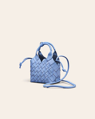 Cala Jade Blue woven handbag on a light beige background seen from the side