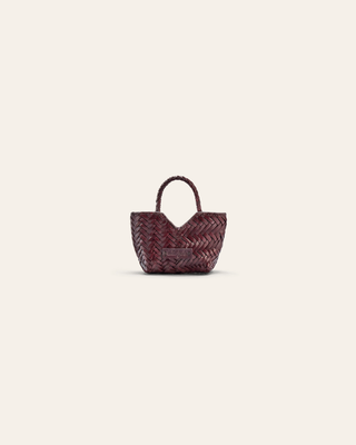 A burgundy woven leather bag charm on a beige background