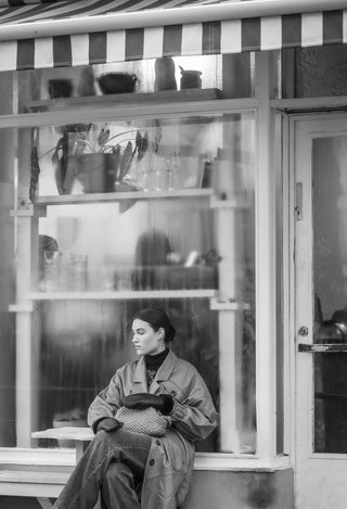 Cala Jade black leather mittens on a model posing against a window
