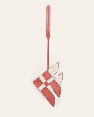 Cala Jade red and white leather bag charm shaped like a fish on a beige background