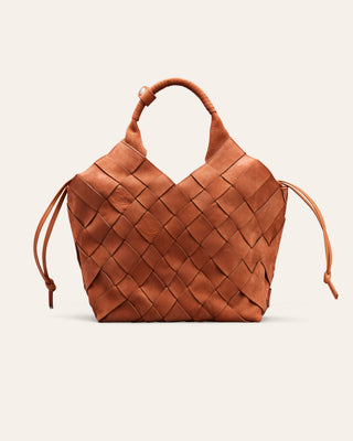 A woven leather handbag in a warm cognac brown, featuring a structured diamond-weave pattern, a single top handle, and drawstring ties on the sides, set against a solid off-white background.