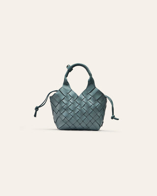 Woven handbag on a light blue background