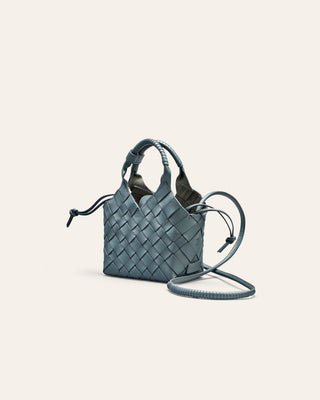Woven handbag on a light blue background