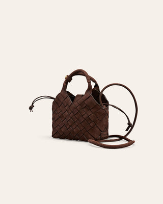 A small woven nubuck leather shoulder bag on a beige background