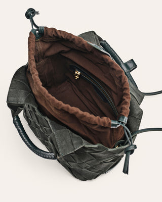 Inside dark green suede shoulder bag on a light gray background