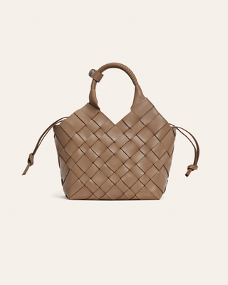 Beige woven handbag on a beige background