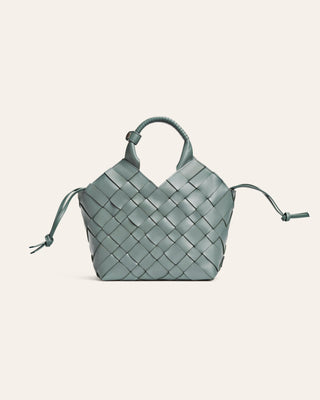 Light blue woven handbag on a light gray background