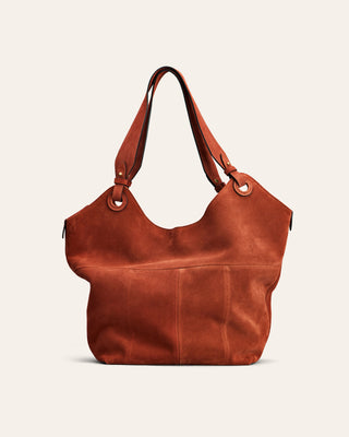 Red suede leather handbag on a beige background