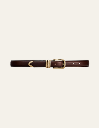 A burgundy belt with gold brass hardware on a beige backgroun