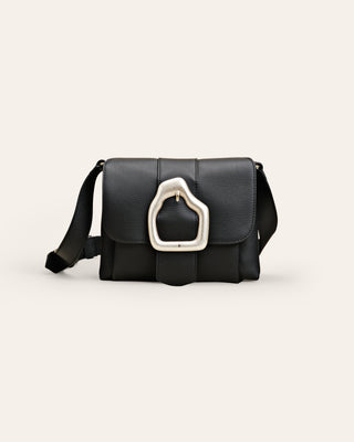Cala Jade black leather shoulder bag with a silver buckle on a beige background