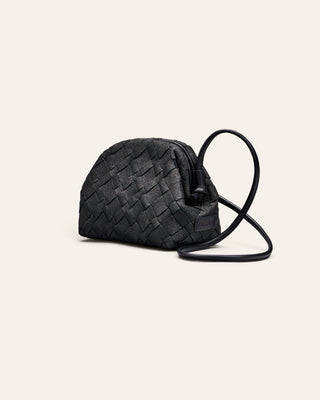 Cala Jade gitter navy woven handbag with a strap on a light beige background