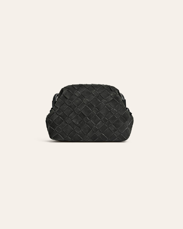 Dark green suede woven handbag on a light beige background