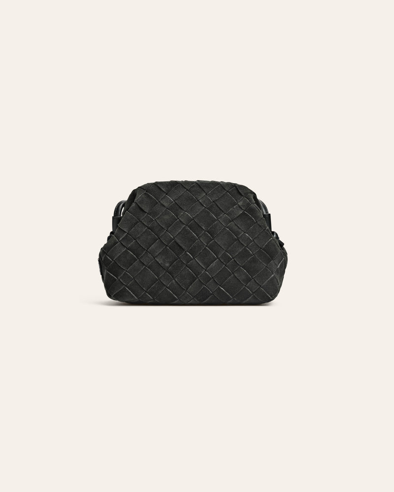 Dark green suede woven handbag on a light beige background