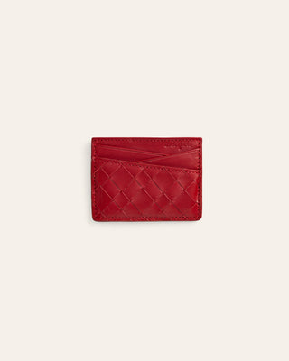A red leather card holder with a woven basketweave pattern, shown flat against a light cream background.