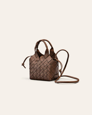 Cala Jade Misu Mini Brown woven leather bag on a light beige background seen from the side