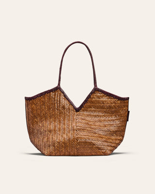 Woven straw tote bag with dark brown handle on a light beige background