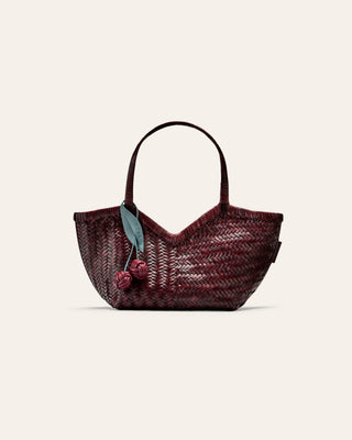 Woven handbag with cherry decorations on a beige background