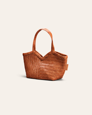 A small woven leather handbag in a warm tan-brown color, featuring a V-shaped top and a single shoulder strap, set against a solid off-white background.