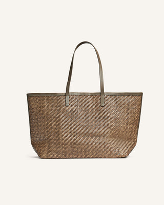 A brown leather bag on a beige backgrounf