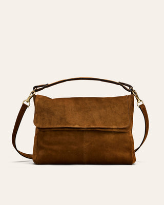 Brown leather handbag with a shoulder strap on a light beige background