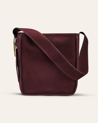 Brown leather crossbody bag on a light beige background