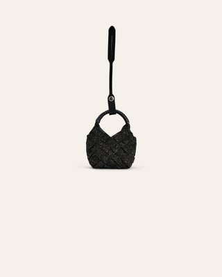 Black textured handbag with a long handle on a light beige background
