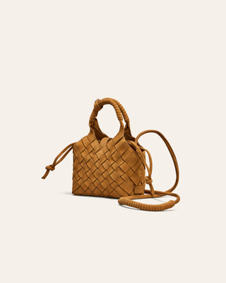 Woven brown handbag with a strap on a beige background