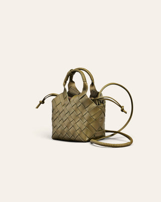 A dark green woen leather handbag on a beige background used for product image