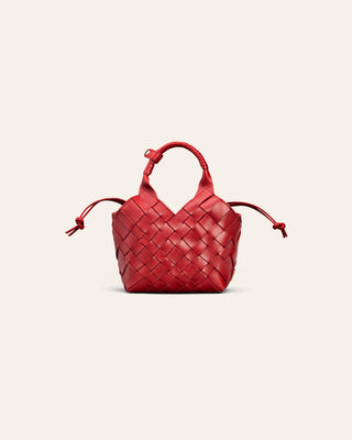A small red woven leather handbag with a top handle and drawstring ties, centered on a light beige background.