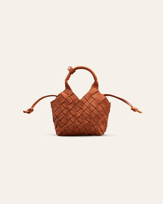 A rustic red nubuck leather bag on a beige background