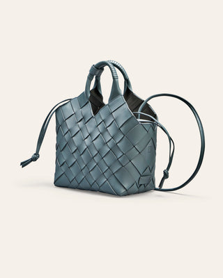 A blue woven leather handbag on a light beige background