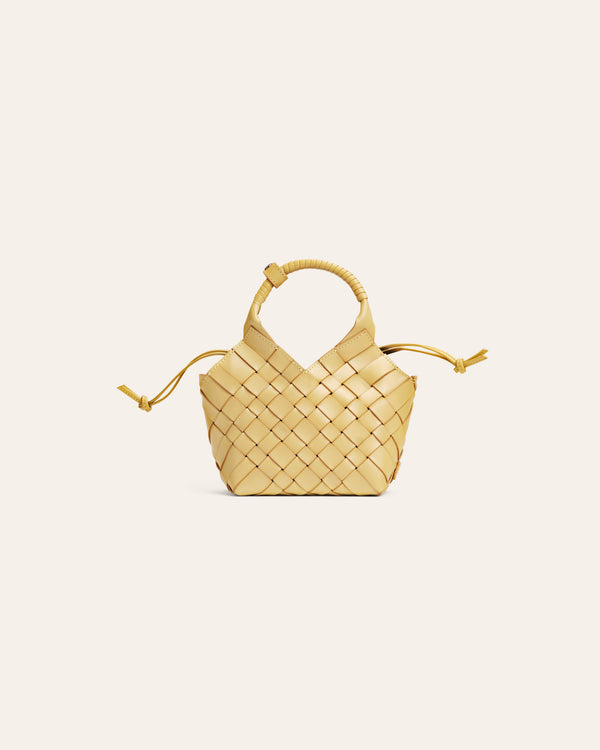 Small woven yellow handbag on a light beige background