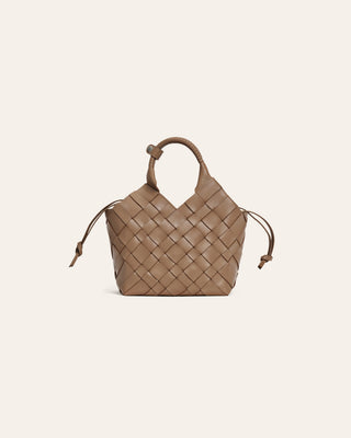 Brown woven leather bag on a beige background