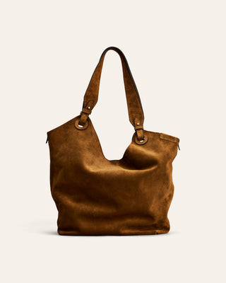 A brown suede hobo shoulder bag with double leather straps and metal hardware, photographed against a solid beige background.