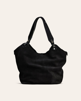 Black suede handbag on a beige background